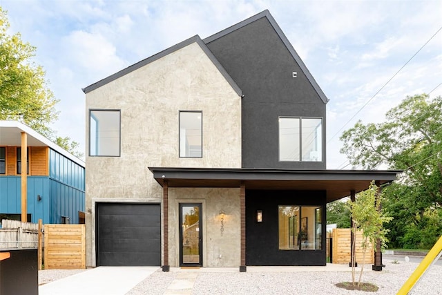2301 Canterbury, Austin, TX 78702 - contemporary house featuring an attached garage, stucco siding, a porch, and driveway