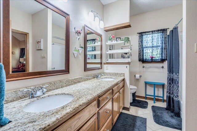 336 Primrose Dr, Kyle, TX 78640 - full bath featuring toilet, double vanity, tile patterned floors, and curtained shower