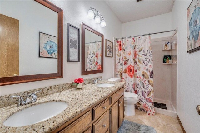 336 Primrose Dr, Kyle, TX 78640 - bathroom featuring toilet, a shower with shower curtain, double vanity, and tile patterned floors
