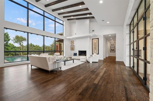 9517 Veletta Pl, Austin, TX 78735 - living room with a towering ceiling, wood finished floors, beam ceiling, recessed lighting, and a fireplace with raised hearth