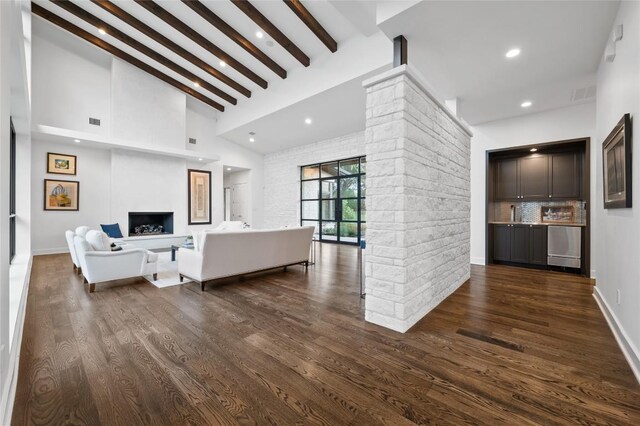 9517 Veletta Pl, Austin, TX 78735 - living room featuring dark wood-type flooring, recessed lighting, a fireplace with raised hearth, bar area, and baseboards