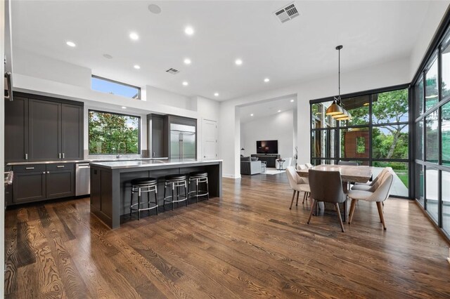 9517 Veletta Pl, Austin, TX 78735 - kitchen featuring a kitchen island, stainless steel built in fridge, dark wood-style flooring, light countertops, and a breakfast bar area
