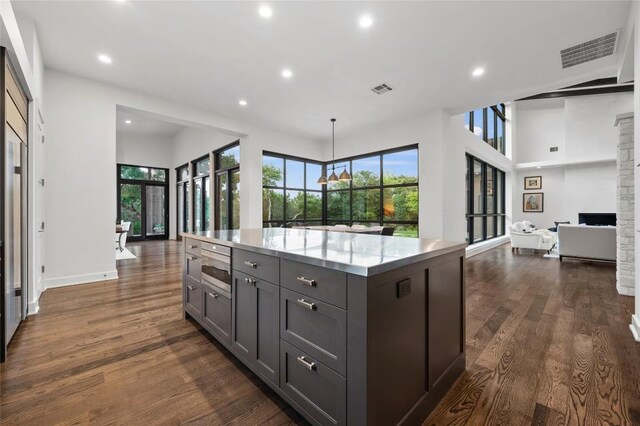 9517 Veletta Pl, Austin, TX 78735 - kitchen with recessed lighting, gray cabinets, healthy amount of natural light, dark wood finished floors, and a center island