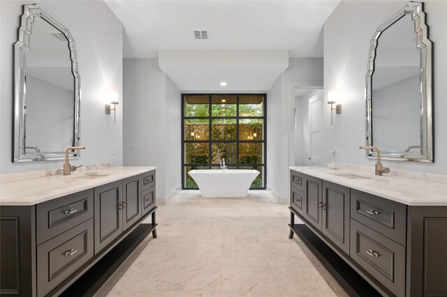 9517 Veletta Pl, Austin, TX 78735 - bathroom with two vanities, a soaking tub, and baseboards