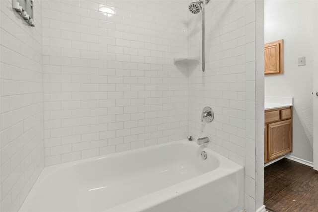 4700 Fallenash Dr, Austin, TX 78725 - full bathroom with wood finished floors, vanity,  shower combination, and baseboards