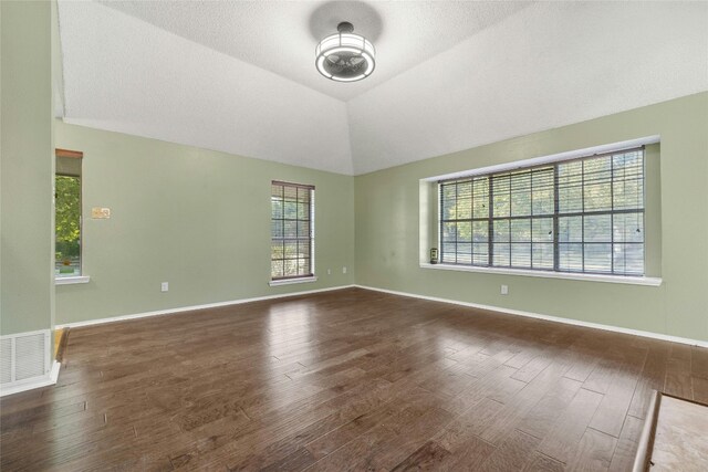 4700 Fallenash Dr, Austin, TX 78725 - unfurnished room with wood finished floors, plenty of natural light, vaulted ceiling, and baseboards