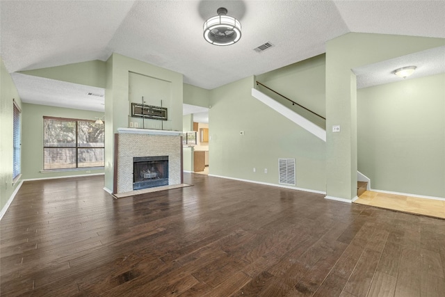 4700 Fallenash Dr, Austin, TX 78725 - unfurnished living room with vaulted ceiling, dark wood-style flooring, stairs, baseboards, and a textured ceiling