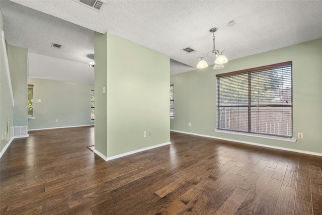 4700 Fallenash Dr, Austin, TX 78725 - spare room with a textured ceiling, wood finished floors, a chandelier, healthy amount of natural light, and baseboards