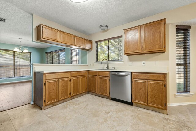 4700 Fallenash Dr, Austin, TX 78725 - kitchen with stainless steel dishwasher, a sink, a textured ceiling, a chandelier, and a peninsula