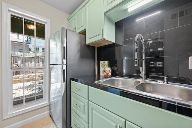 3102 Glen Ora St Unit 102, Austin, TX 78704 - kitchen featuring green cabinets, decorative backsplash, freestanding refrigerator, and dark countertops
