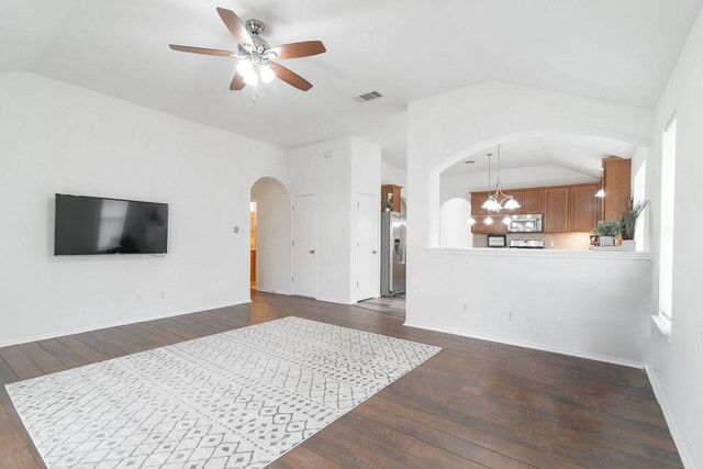 1310 Rainbow Parke Dr, Round Rock, TX 78665 - living room with vaulted ceiling, arched walkways, ceiling fan, dark wood-style floors, and healthy amount of natural light