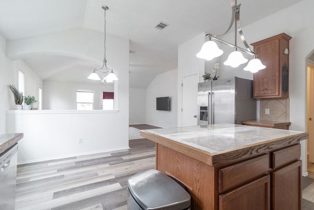 1310 Rainbow Parke Dr, Round Rock, TX 78665 - kitchen featuring stainless steel appliances, vaulted ceiling, light wood finished floors, a chandelier, and tasteful backsplash