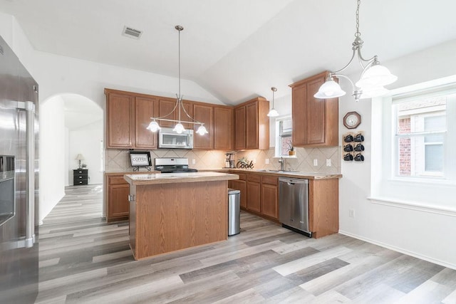 1310 Rainbow Parke Dr, Round Rock, TX 78665 - kitchen featuring stainless steel appliances, light wood-style flooring, light countertops, and vaulted ceiling