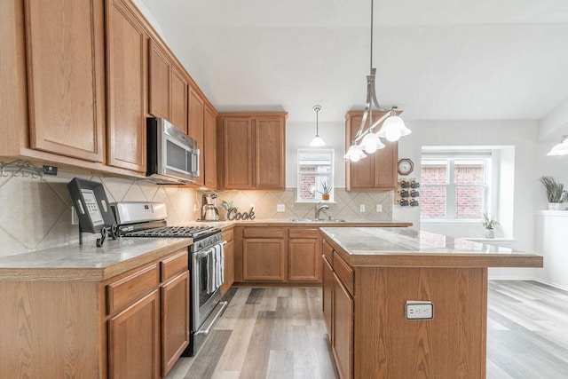 1310 Rainbow Parke Dr, Round Rock, TX 78665 - kitchen featuring appliances with stainless steel finishes, a sink, light wood finished floors, and a center island