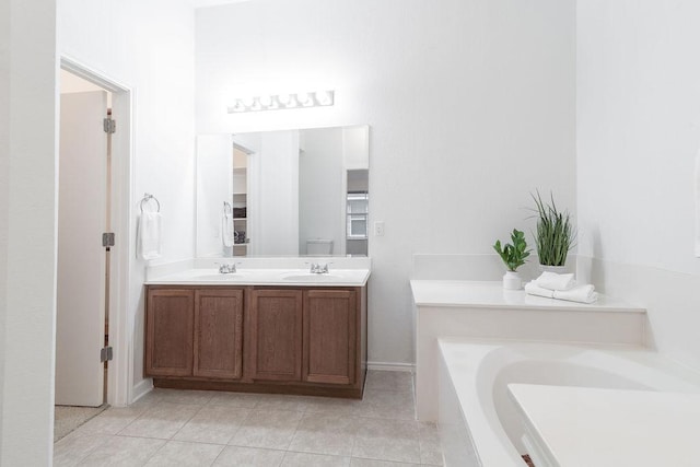 1310 Rainbow Parke Dr, Round Rock, TX 78665 - bathroom featuring a garden tub, double vanity, tile patterned floors, and baseboards