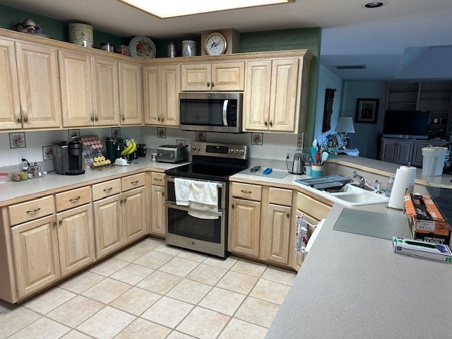 145 Turkey Run, Meadowlakes, TX 78654 - kitchen featuring appliances with stainless steel finishes, a sink, light countertops, light brown cabinets, and light tile patterned flooring