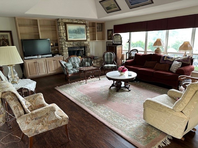 145 Turkey Run, Meadowlakes, TX 78654 - living room with healthy amount of natural light, built in features, dark wood-style flooring, and a stone fireplace