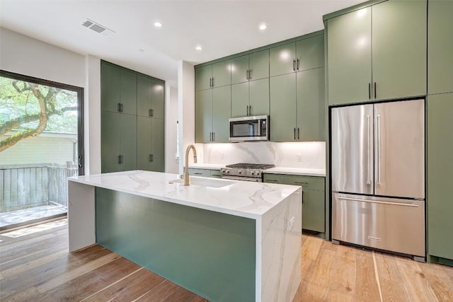 3208 Clawson Rd Unit 3A, Austin, TX 78704 - kitchen featuring high end appliances, green cabinets, light wood finished floors, and recessed lighting