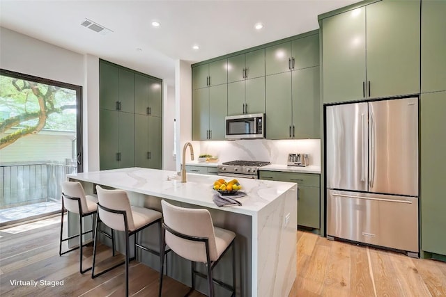 3208 Clawson Rd Unit 3A, Austin, TX 78704 - kitchen with appliances with stainless steel finishes, green cabinetry, light wood-style flooring, and recessed lighting