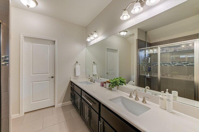 9424 Sawyer Fay Ln, Austin, TX 78748 - full bath featuring double vanity, tile patterned floors, a shower stall, toilet, and baseboards