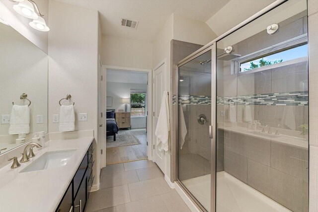 9424 Sawyer Fay Ln, Austin, TX 78748 - ensuite bathroom featuring vanity, healthy amount of natural light, a stall shower, and tile patterned floors