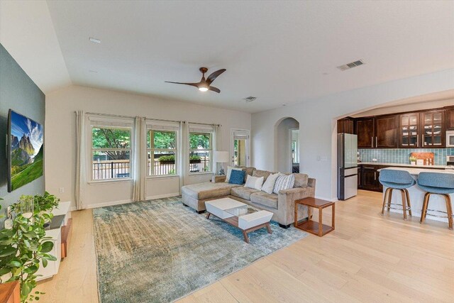 9424 Sawyer Fay Ln, Austin, TX 78748 - living area with arched walkways, light wood finished floors, ceiling fan, and vaulted ceiling