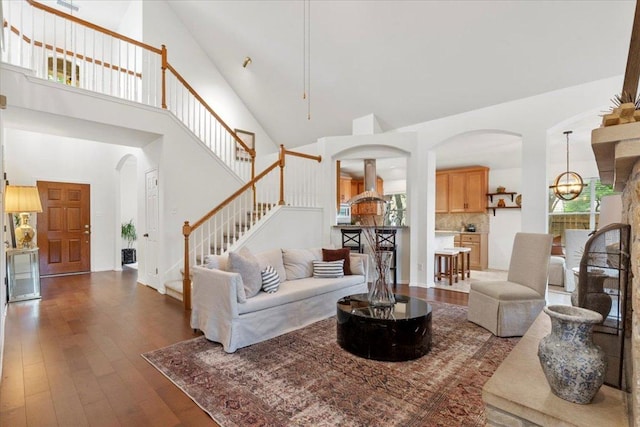 12501 Bright Sky Overlook, Austin, TX 78732 - living area featuring high vaulted ceiling, arched walkways, wood-type flooring, stairway, and a chandelier