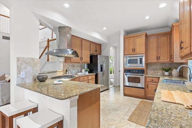 12501 Bright Sky Overlook, Austin, TX 78732 - kitchen with stainless steel appliances, wall chimney exhaust hood, arched walkways, tasteful backsplash, and light stone counters
