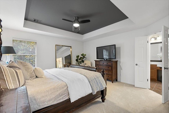 12501 Bright Sky Overlook, Austin, TX 78732 - bedroom with a tray ceiling, light carpet, ensuite bath, and ceiling fan