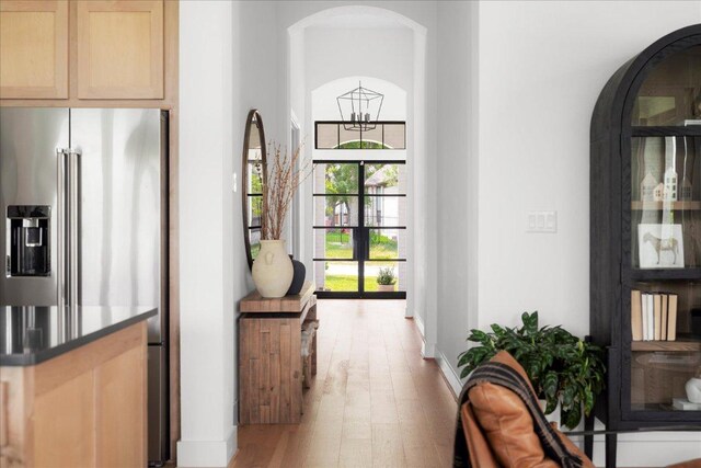 482 Running Bird Rd, Austin, TX 78737 - hall featuring arched walkways, wood finished floors, and baseboards