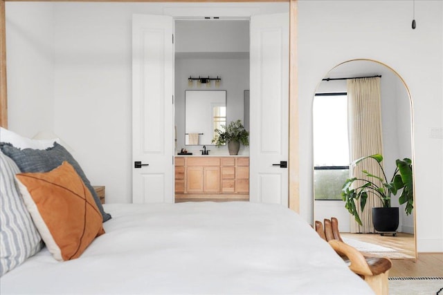 482 Running Bird Rd, Austin, TX 78737 - bedroom with wood finished floors, a sink, and ensuite bath