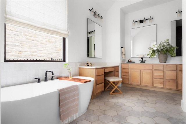 482 Running Bird Rd, Austin, TX 78737 - full bathroom featuring a freestanding tub, two vanities, backsplash, and high vaulted ceiling