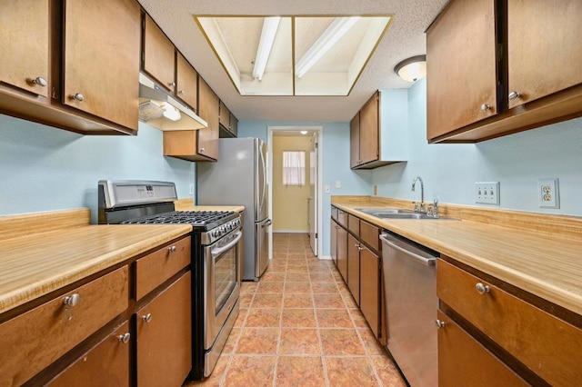 3921 Leafield Dr, Austin, TX 78749 - kitchen featuring stainless steel appliances, under cabinet range hood, light countertops, and brown cabinets