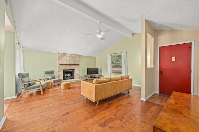 3921 Leafield Dr, Austin, TX 78749 - living room with hardwood / wood-style flooring, a textured ceiling, a ceiling fan, baseboards, and a brick fireplace