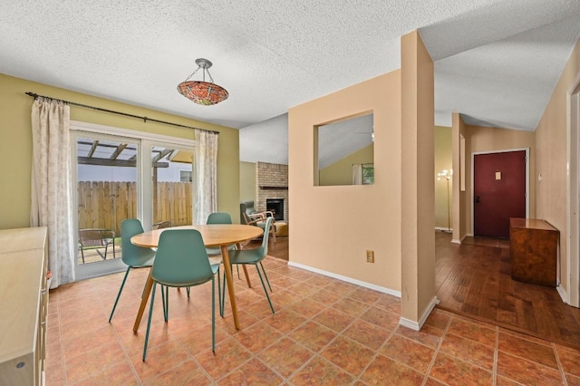3921 Leafield Dr, Austin, TX 78749 - dining space with lofted ceiling, a brick fireplace, baseboards, and a textured ceiling