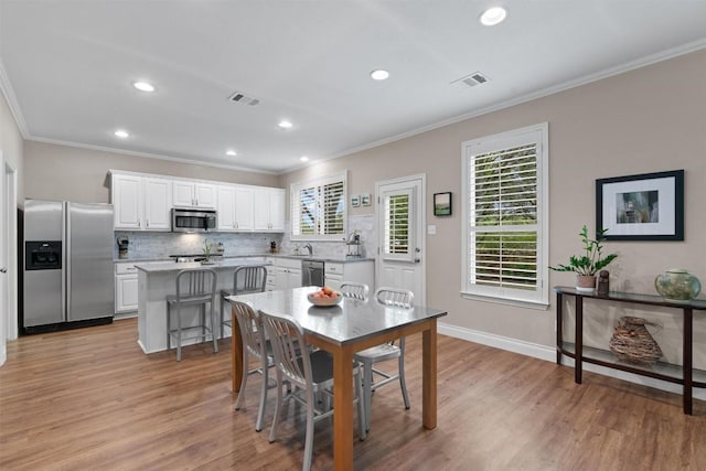2125 Village View Loop, Pflugerville, TX 78660 - dining area featuring ornamental molding, light wood-style flooring, recessed lighting, and baseboards