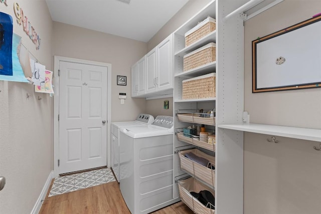 2125 Village View Loop, Pflugerville, TX 78660 - laundry area featuring cabinet space, light wood-style floors, separate washer and dryer, and baseboards