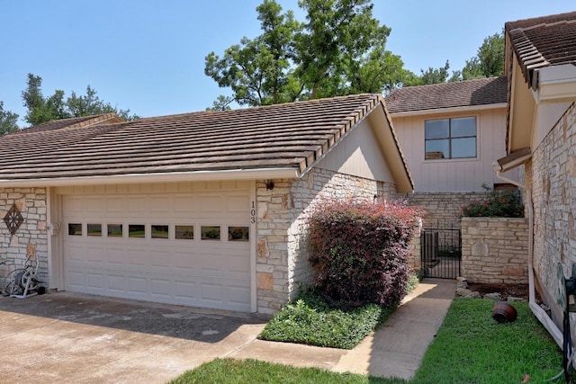 11512 Tin Cup Dr Unit 103, Austin, TX 78750 - view of front of home with stone siding, an attached garage, and a gate