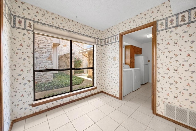 11512 Tin Cup Dr Unit 103, Austin, TX 78750 - unfurnished room featuring wallpapered walls, baseboards, a textured ceiling, and light tile patterned floors