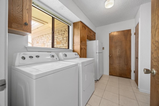 11512 Tin Cup Dr Unit 103, Austin, TX 78750 - laundry room featuring washing machine and dryer, cabinet space, a textured ceiling, and light tile patterned floors