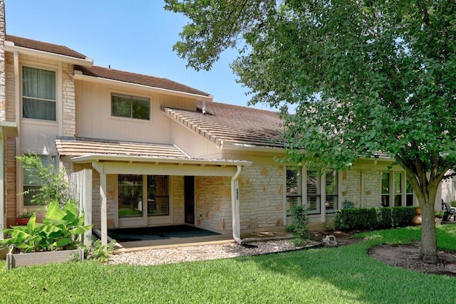 11512 Tin Cup Dr Unit 103, Austin, TX 78750 - rear view of property featuring stone siding, a lawn, and a patio area