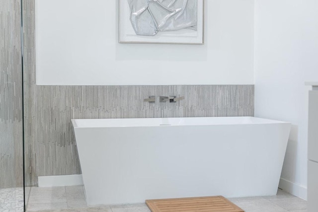 2601 Great Owl Pass, Leander, TX 78641 - full bath featuring a freestanding tub, wainscoting, and tile patterned flooring