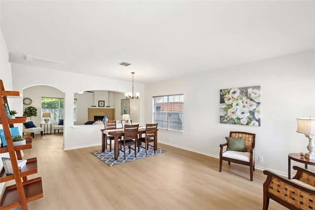 1113 Red Ranch Cir, Cedar Park, TX 78613 - dining area featuring light wood-style floors, arched walkways, a chandelier, and baseboards