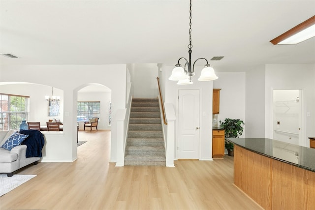 1113 Red Ranch Cir, Cedar Park, TX 78613 - staircase with a chandelier, arched walkways, wood finished floors, and baseboards