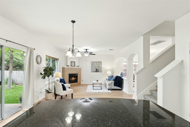 1113 Red Ranch Cir, Cedar Park, TX 78613 - living area featuring healthy amount of natural light, light wood-style flooring, a tile fireplace, and stairway