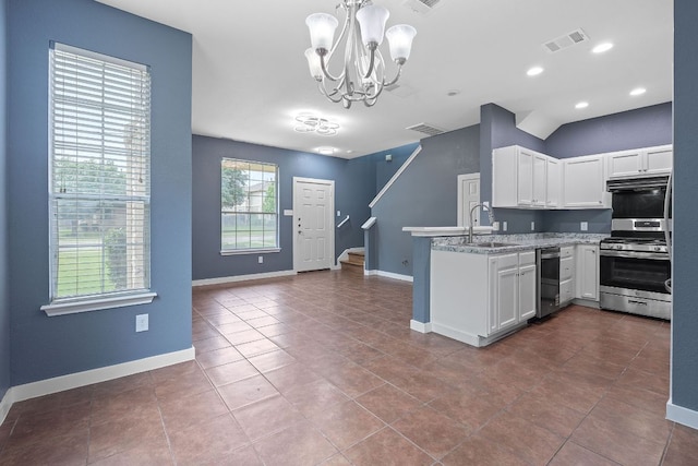 14517 Harris Ridge Blvd Unit B, Pflugerville, TX 78660 - kitchen with appliances with stainless steel finishes, a sink, white cabinets, a chandelier, and a peninsula
