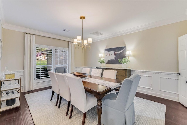 22 Wingreen Loop, The Hills, TX 78738 - dining area featuring a chandelier, crown molding, wood finished floors, a wainscoted wall, and a decorative wall