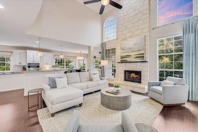 22 Wingreen Loop, The Hills, TX 78738 - living room with hardwood / wood-style floors, a ceiling fan, healthy amount of natural light, a towering ceiling, and a fireplace