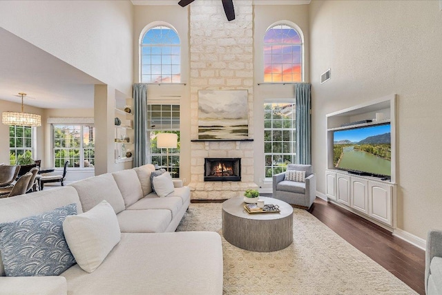22 Wingreen Loop, The Hills, TX 78738 - living room featuring dark wood-style flooring, a high ceiling, baseboards, a chandelier, and ceiling fan