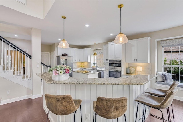 22 Wingreen Loop, The Hills, TX 78738 - kitchen with appliances with stainless steel finishes, healthy amount of natural light, baseboards, tasteful backsplash, and recessed lighting